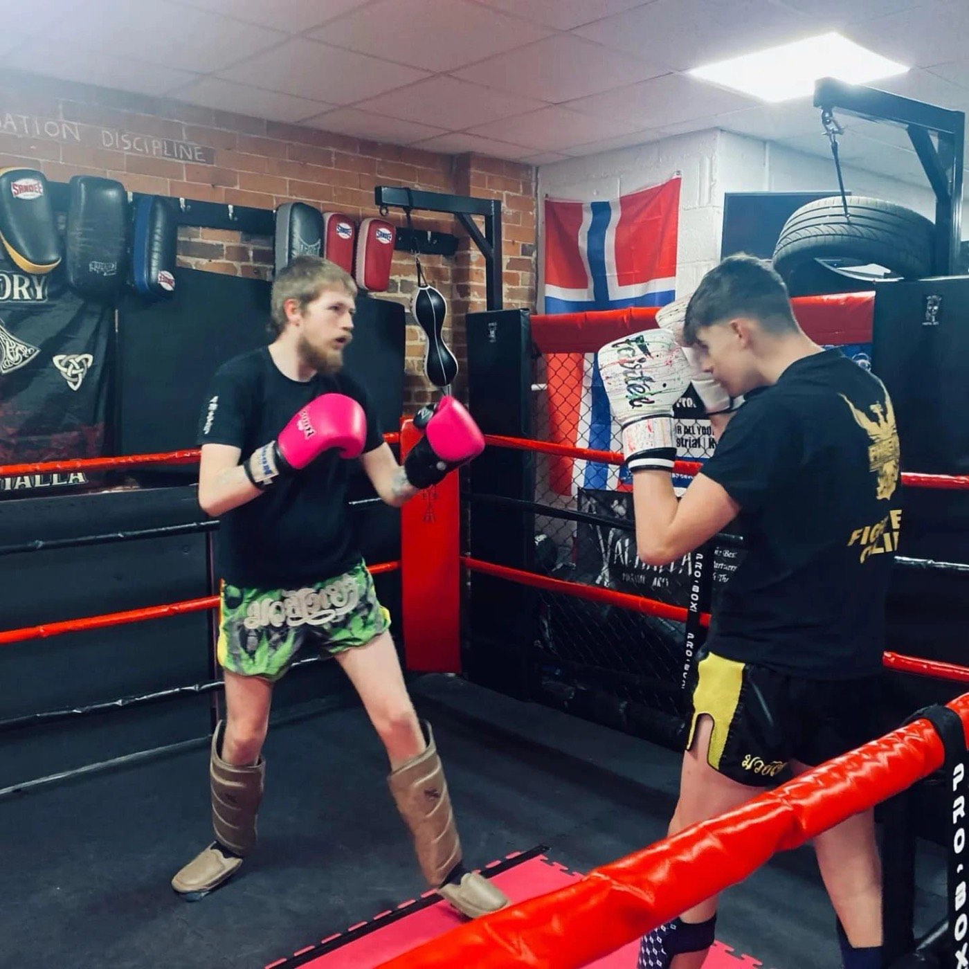 Coach holding pads for a fighter at Valhalla Martial Arts Weymouth
