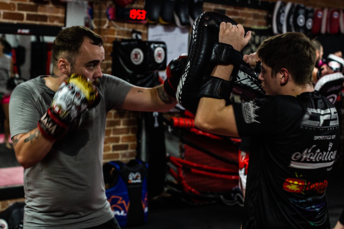 Coach holding pads for a fighter at Valhalla Martial Arts